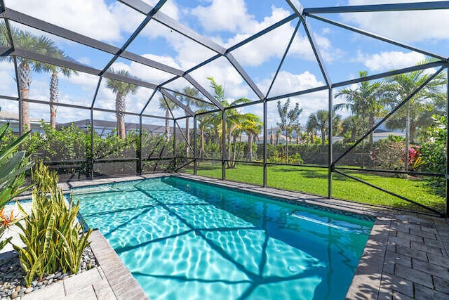 outdoor pool featuring a lanai, a yard, and a patio area