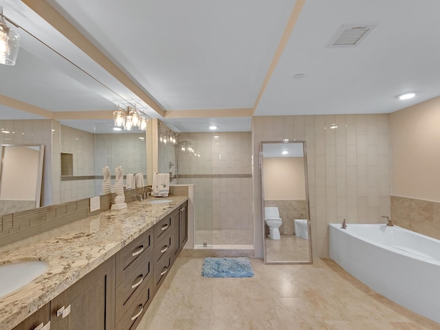 bathroom featuring visible vents, double vanity, a tile shower, tile walls, and a sink