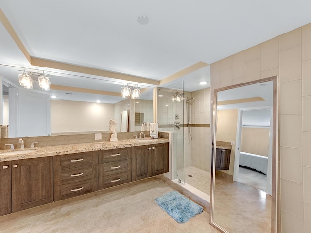 bathroom with double vanity, a stall shower, and a sink