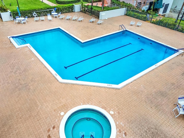 community pool with a patio and fence