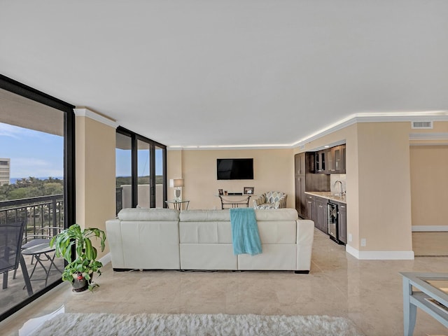 living room with a wall of windows, visible vents, and baseboards