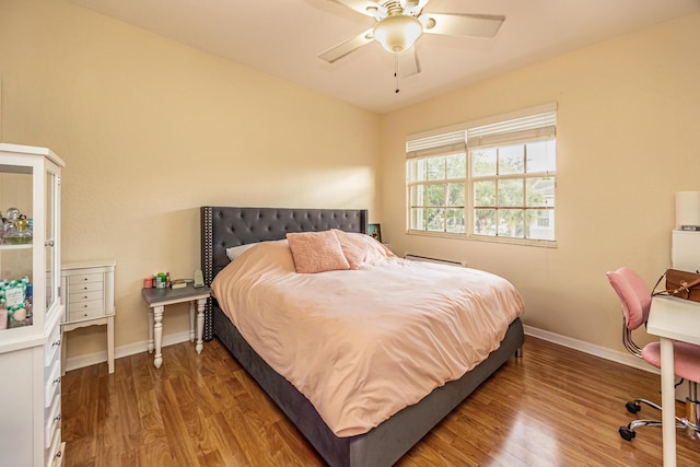 bedroom with ceiling fan, baseboards, and wood finished floors