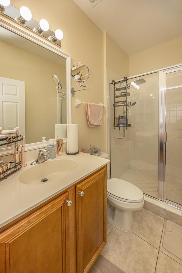 full bathroom featuring tile patterned flooring, toilet, a stall shower, and vanity