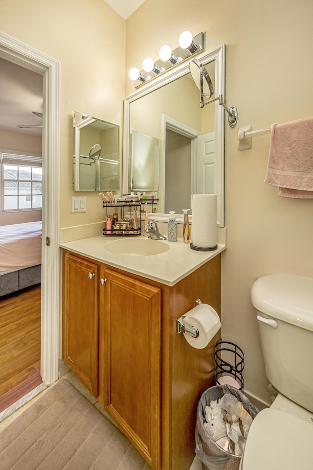 bathroom featuring vanity, toilet, ensuite bathroom, and wood finished floors