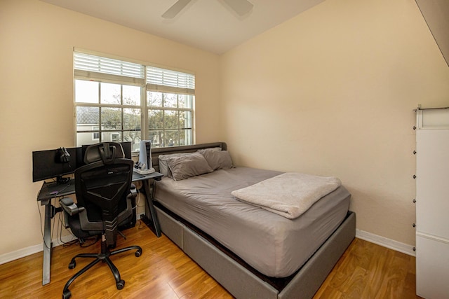 bedroom with wood finished floors, baseboards, and ceiling fan