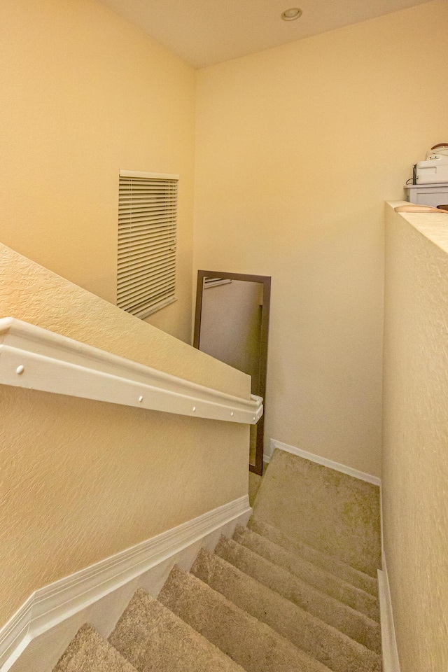 stairway with baseboards and visible vents