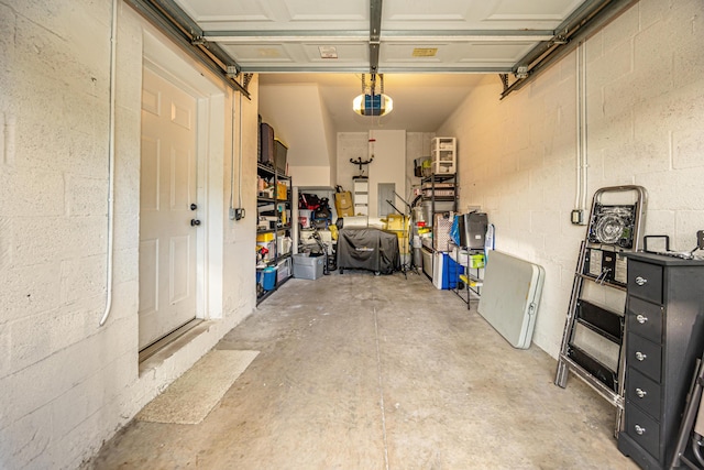 garage featuring concrete block wall and a garage door opener