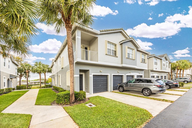 view of front facade with a front yard, a garage, driveway, and stucco siding