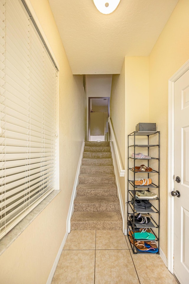 stairway featuring tile patterned floors and baseboards