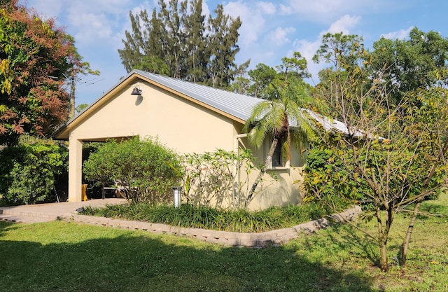 view of property exterior with stucco siding and a yard