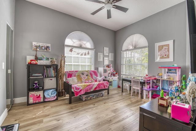 recreation room featuring visible vents, baseboards, a ceiling fan, and wood finished floors