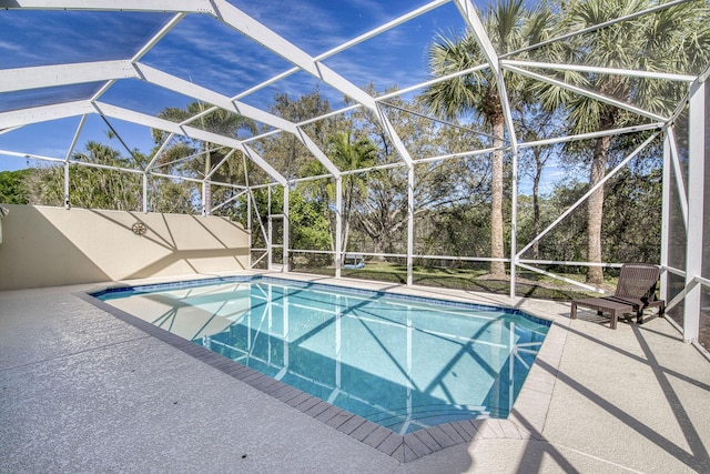 view of pool with glass enclosure, a patio, and a fenced in pool