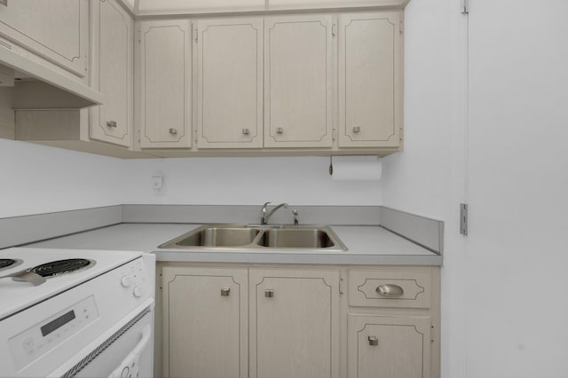 kitchen featuring light countertops, under cabinet range hood, range with electric stovetop, and a sink