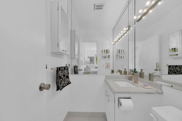 ensuite bathroom featuring visible vents, toilet, vanity, and ensuite bathroom