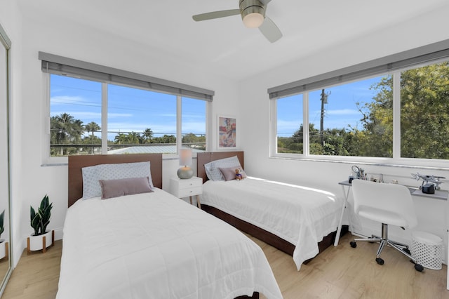 bedroom featuring multiple windows, light wood-type flooring, and ceiling fan