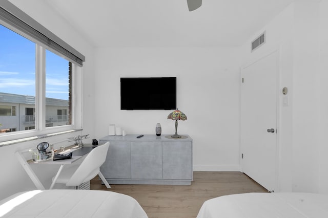 bedroom featuring light wood-style flooring, baseboards, visible vents, and ceiling fan