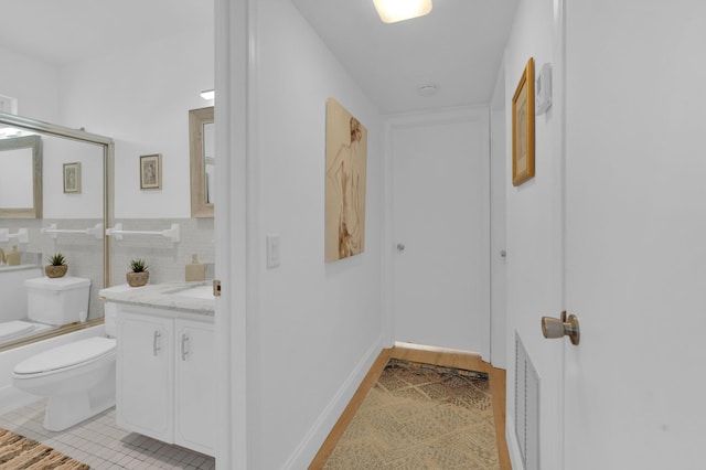 corridor featuring a wainscoted wall, tile walls, light tile patterned floors, and visible vents