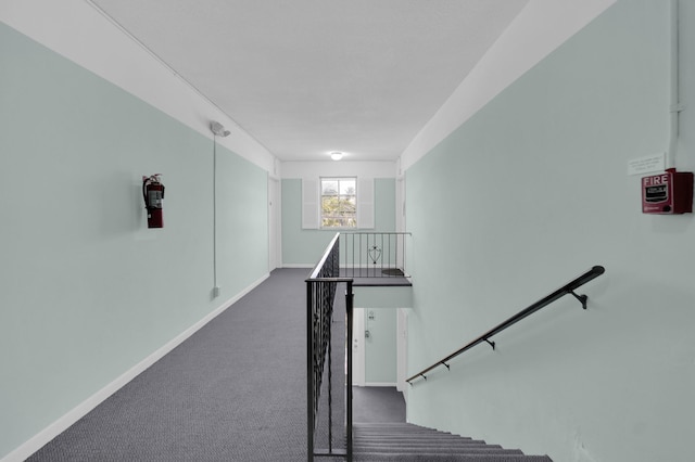 stairway featuring baseboards and carpet floors