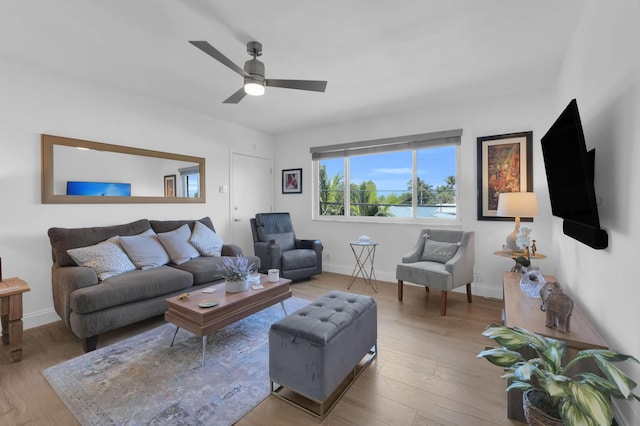 living room with a ceiling fan, wood finished floors, and baseboards