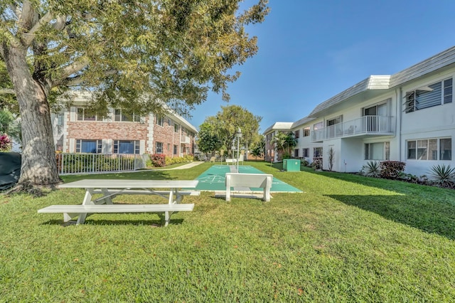 view of property's community featuring a residential view, shuffleboard, and a yard