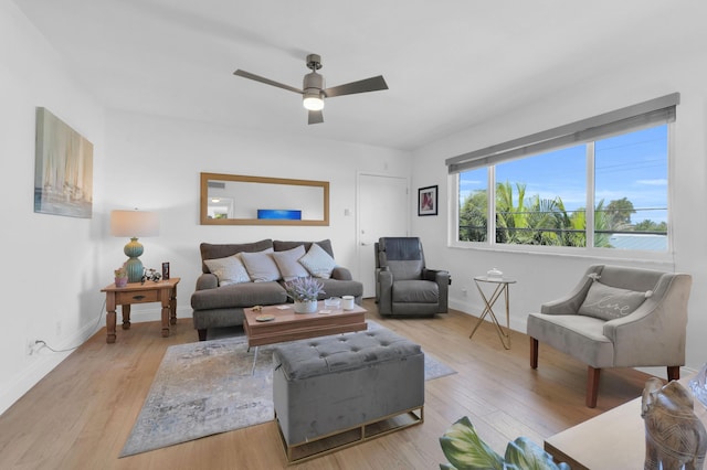 living room featuring wood finished floors, baseboards, and ceiling fan