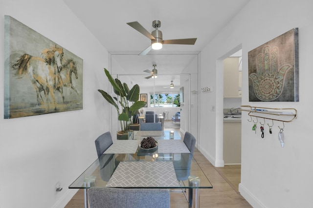 dining room featuring baseboards, ceiling fan, and wood finished floors