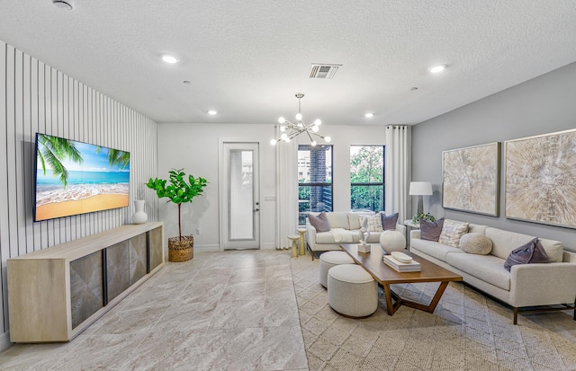 living room with visible vents, recessed lighting, a textured ceiling, and an inviting chandelier