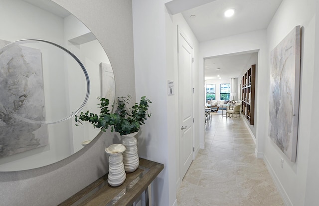 hallway with recessed lighting and baseboards