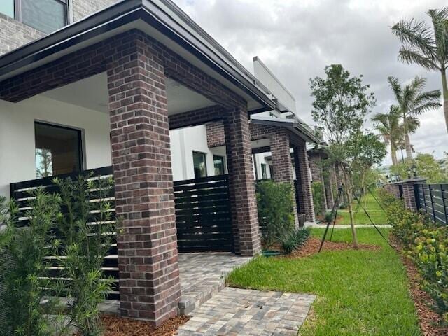 view of home's exterior with brick siding and fence