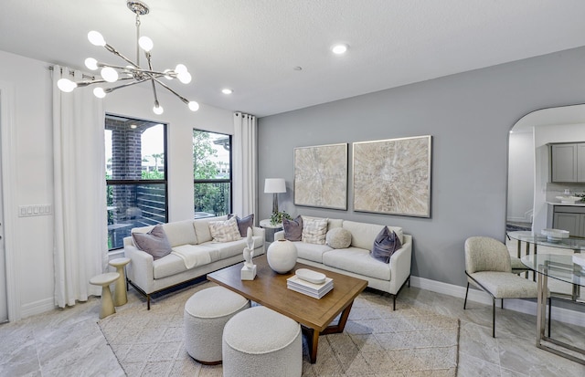 living area featuring baseboards, recessed lighting, an inviting chandelier, arched walkways, and a textured ceiling