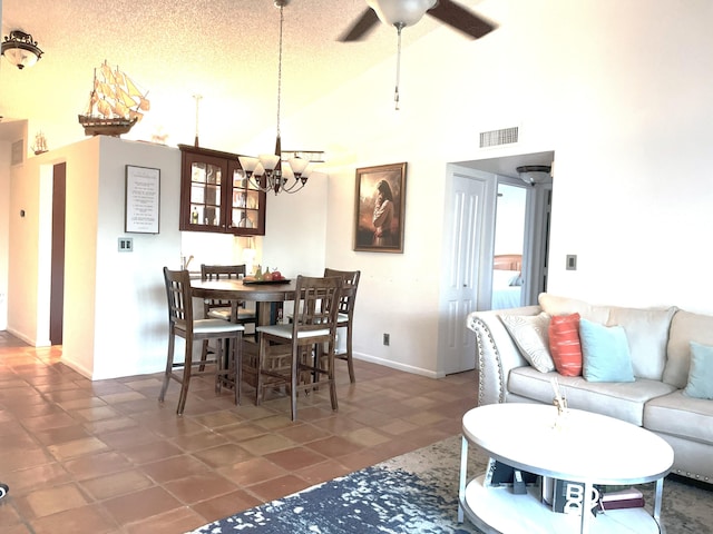 dining area with visible vents, high vaulted ceiling, ceiling fan with notable chandelier, a textured ceiling, and baseboards