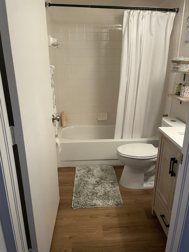 full bathroom featuring vanity, toilet, wood finished floors, and shower / bath combo