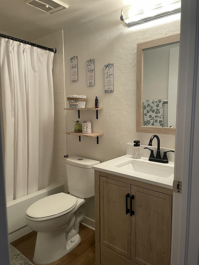 full bathroom with visible vents, toilet, wood finished floors, and a textured wall