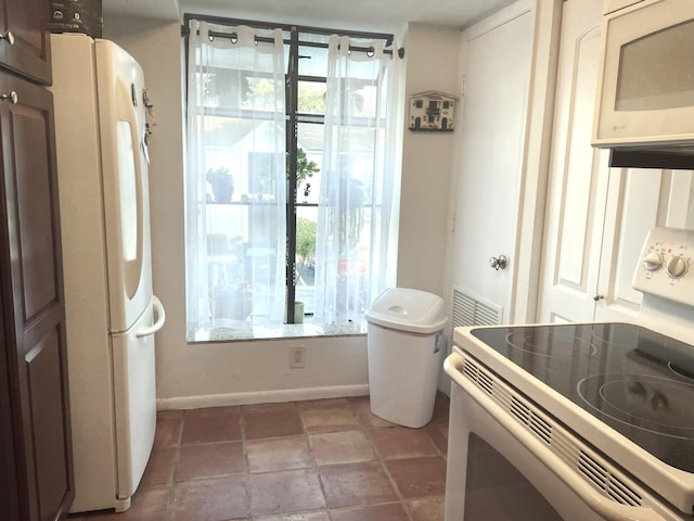 interior space featuring baseboards and white appliances