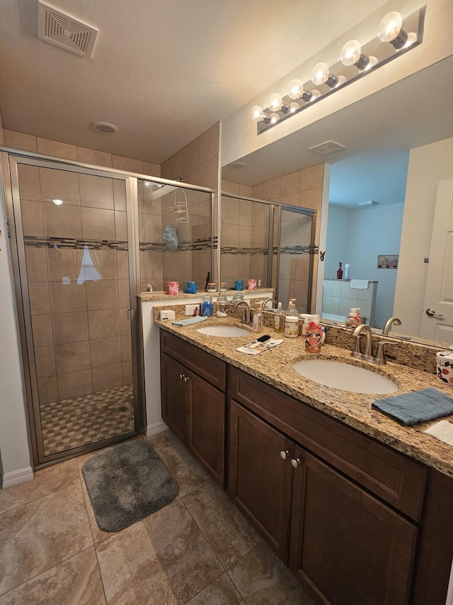 bathroom with a sink, visible vents, and a shower stall