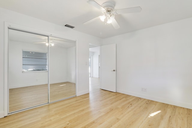 unfurnished bedroom featuring visible vents, light wood-style flooring, a ceiling fan, a closet, and baseboards