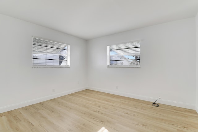 unfurnished room with baseboards and wood finished floors