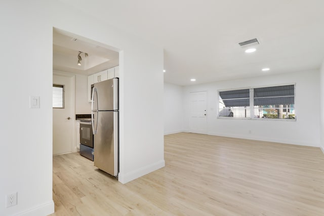 interior space featuring a wealth of natural light, visible vents, baseboards, and light wood-style flooring