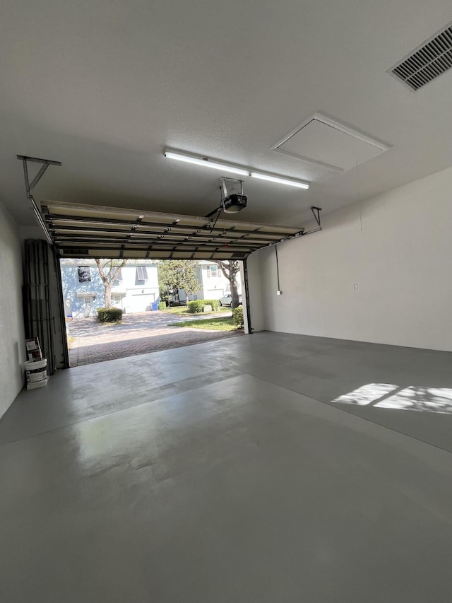 garage featuring visible vents and a garage door opener