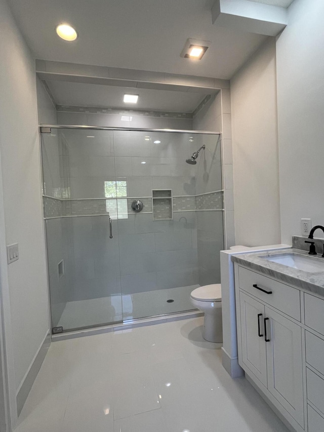 bathroom with toilet, a stall shower, and vanity