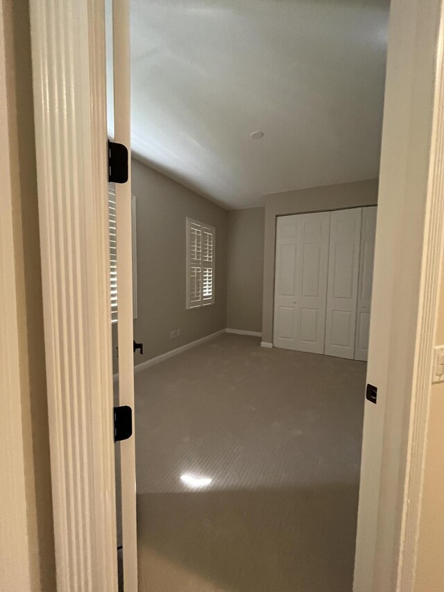 unfurnished room with baseboards and carpet