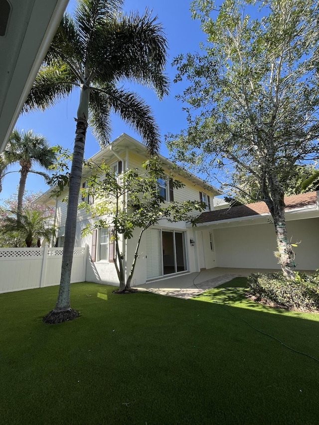 back of house with a patio, a lawn, and fence