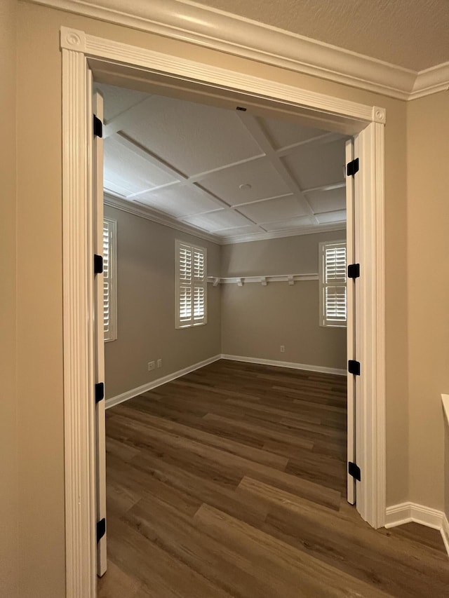 unfurnished room featuring ornamental molding, baseboards, and wood finished floors