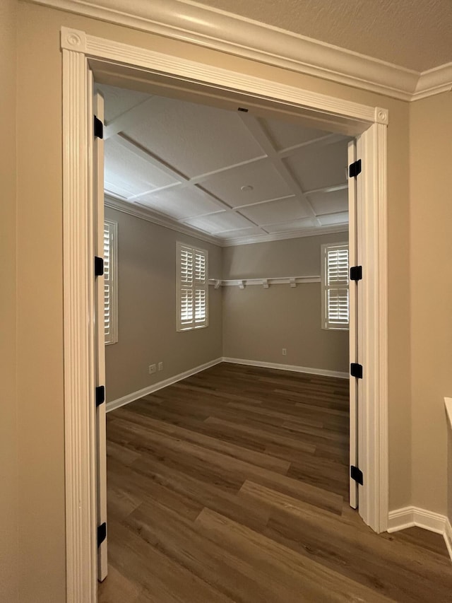 spare room featuring wood finished floors, baseboards, and ornamental molding