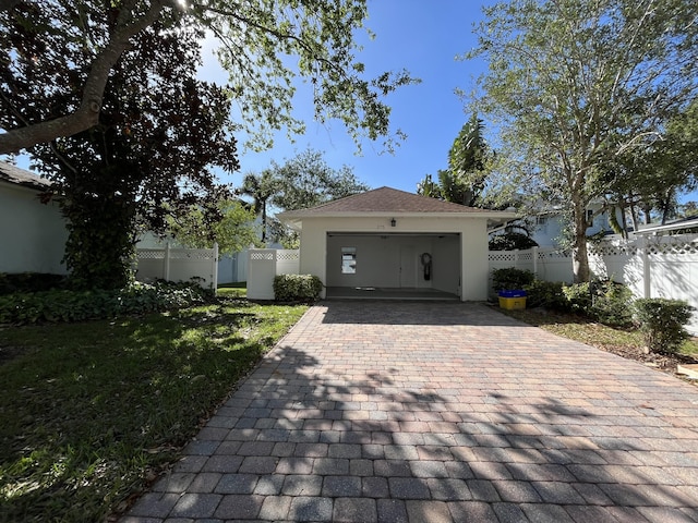 view of front of property with fence, a front yard, stucco siding, decorative driveway, and an attached garage