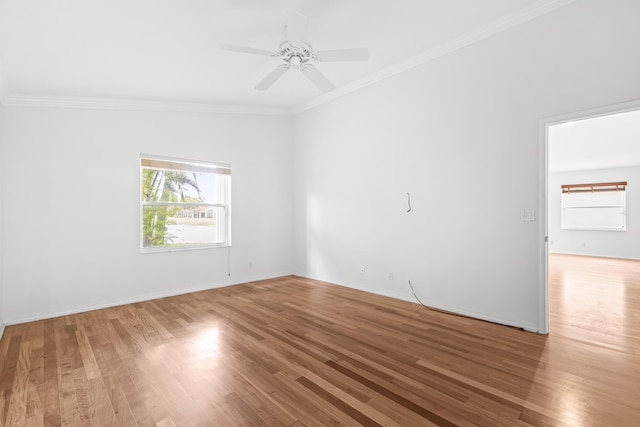 unfurnished room featuring baseboards, crown molding, a ceiling fan, and wood finished floors