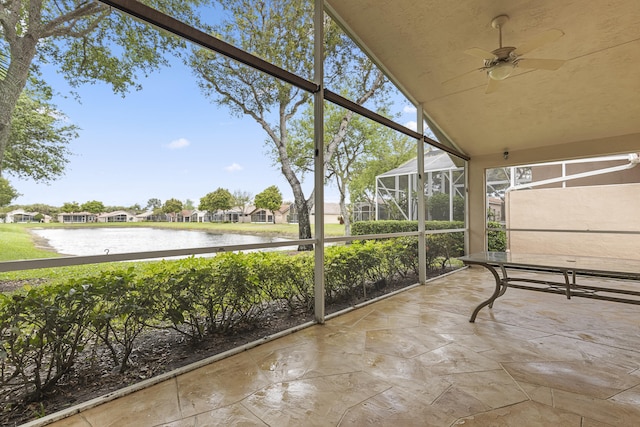 unfurnished sunroom featuring a water view and ceiling fan