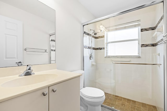 bathroom featuring toilet, a stall shower, and vanity