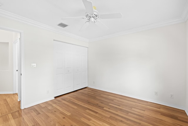 unfurnished bedroom with visible vents, crown molding, light wood-type flooring, and baseboards