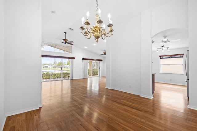 interior space featuring ceiling fan, wood finished floors, arched walkways, and a healthy amount of sunlight